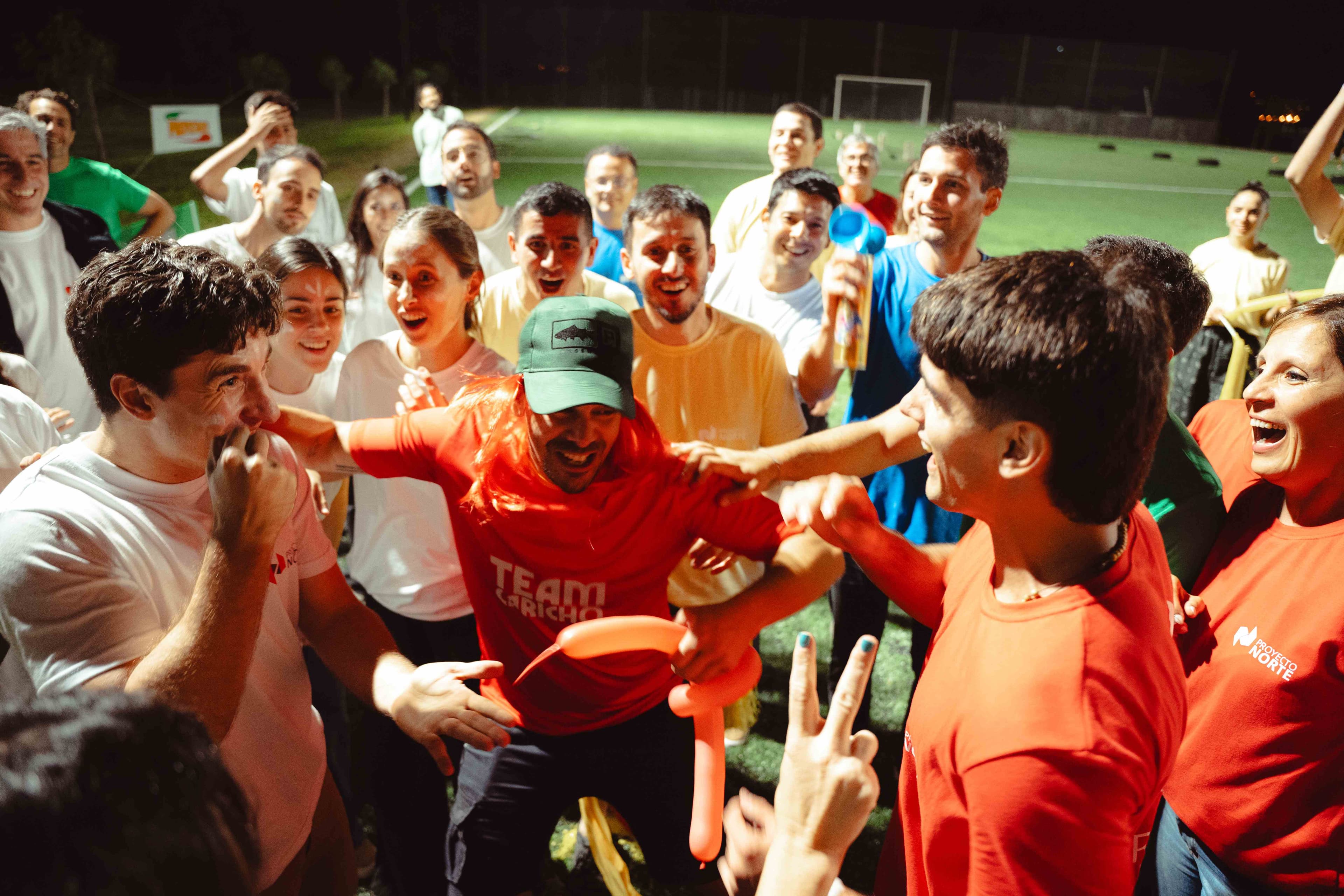 Equipo celebrando en actividad nocturna al aire libre